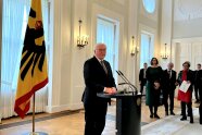 Bundespräsident steht am Rednerpult und spricht zu Leuten