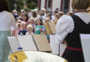 Kinderchor und Musikkapelle begrüßen die Bewertungskommission.